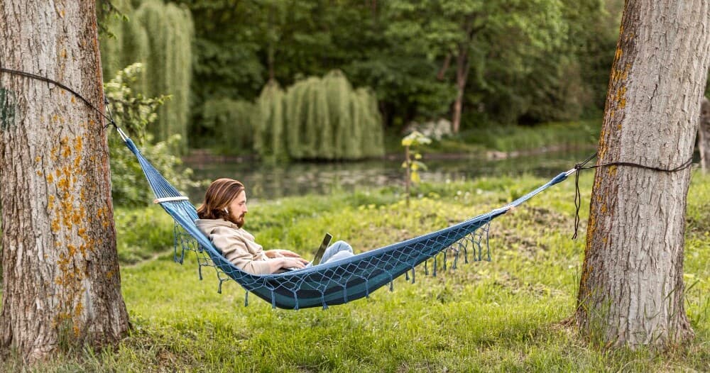 side-view-man-with-laptop-hammock