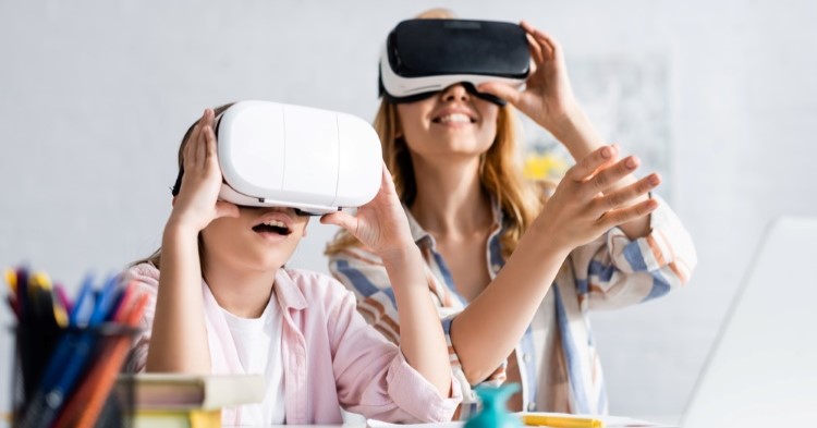 A mother and her daughter, both wearing VR headsets and smiling.