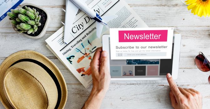 A newsletter model on a tablet device next to a newspaper, hat, and sunglasses.