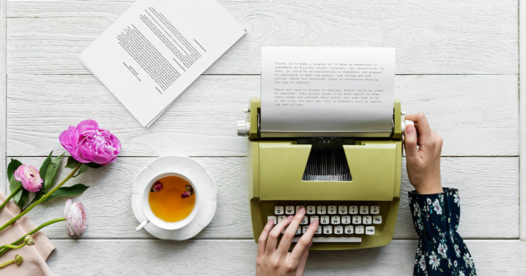 A close-up of hands typing on a typewriter, with scattered notes and a coffee cup, representing writing a book to enter a writing contest.